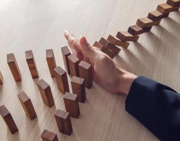 A business person stopping the domino effect